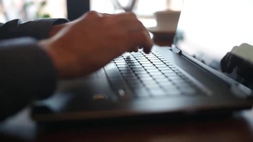 Câmera desliza pelas mãos de um freelancer digitando no teclado do laptop em câmera lenta Empresário trabalhando