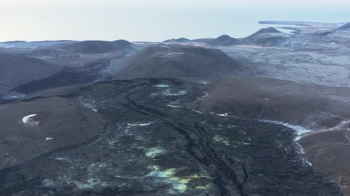 New solid lava river in wild highlands of Iceland, distant view of Atlantic ocean
