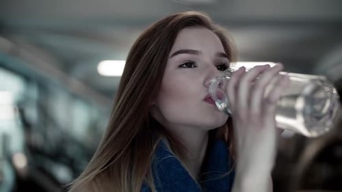 Close-Up of Young Girl or Woman in a Gym, Drinking Water From