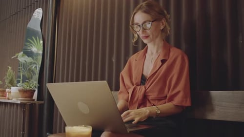 Junge Geschäftsfrau arbeitet im Café am Laptop
