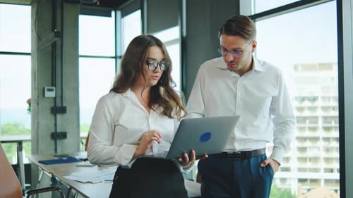 Professional Colleagues Discussing Projects in a Modern Office Environment During Daytime
