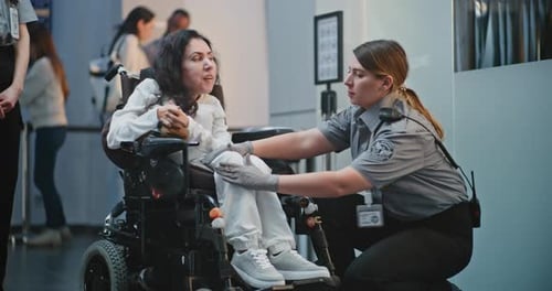 Security Checkpoint in Airport Terminal Female Security Officer Inspects Woman in Wheelchair