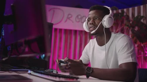 Young Man Playing Video Game on PC at Night