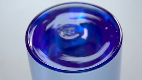 Selektiver Fokus, Nahaufnahme eines Wassertropfens, der in transparentes Glas fällt und Spritzer und r erzeugt