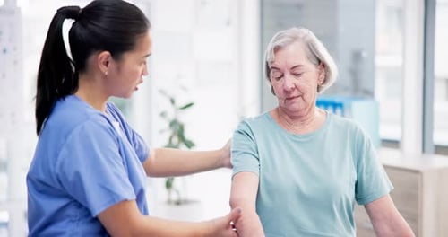 Physical Therapist Helping Senior Woman Lift Weights