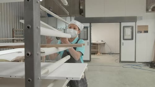 Female worker in factory warehouse with boards