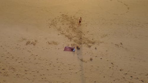 A stylistic drone shot of a man practicing Muay Thai on a Portuguese beach in Costa Da Caparica, end