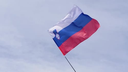 Slovenian Flag Waving Against Light Blue Sky