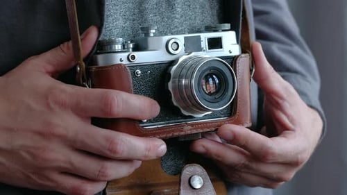 Person Adjusts Vintage Silver and Black Camera