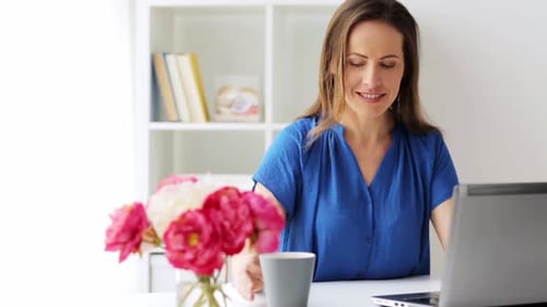 Woman working at desk, home office environment