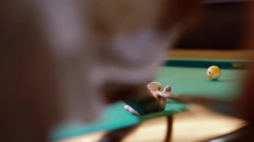 Un jeune joueur de billard frappe la boule blanche avec la queue pour lancer une boule de billard américaine orange dans le