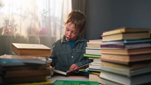 Boy Reading Book Surrounded by Stacks of Books