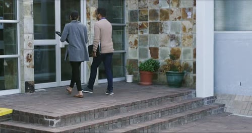 Vídeo en 4K de un joven y una mujer entrando juntos a un edificio