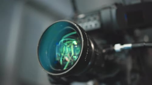 Close Up Cinema Lens Reflecting Green Blue LED Studio Lights with Precision Optics Detail