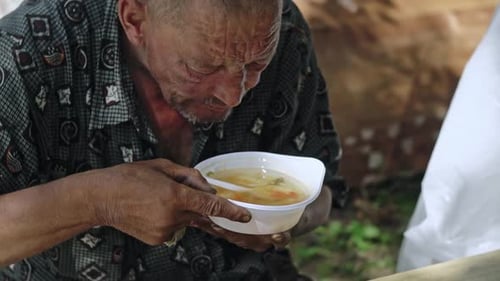 Senior Man Eating Soup Outdoors
