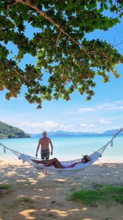 a Man and a Woman are Laying in a Hammock on the Beach Koh Mak Thailand