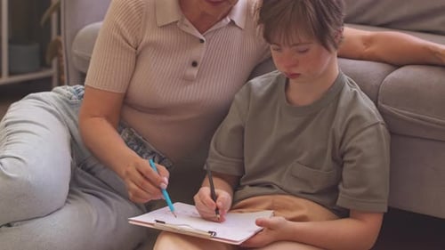Mother Assists Child with Drawing on Living Room Floor