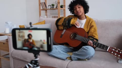 Woman with Guitar Recording Video at Home