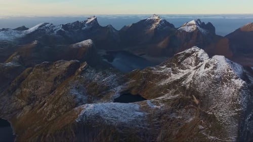 Aerial Gaze at SnowCapped Mountains and Islands in Norway at Sunset with Dark Blue Clouds