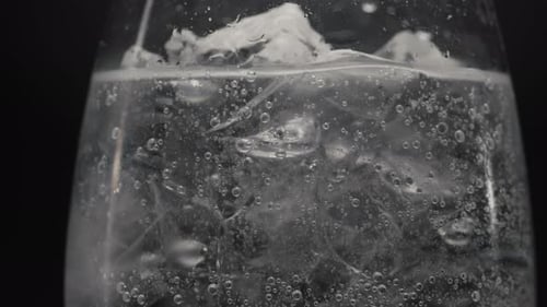Ice Cubes and Bubbles in Glass of Soda