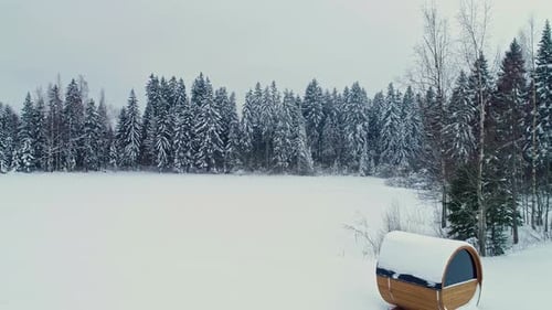 Winter Wonderland: Snow-Covered Forest and Barrel Sauna