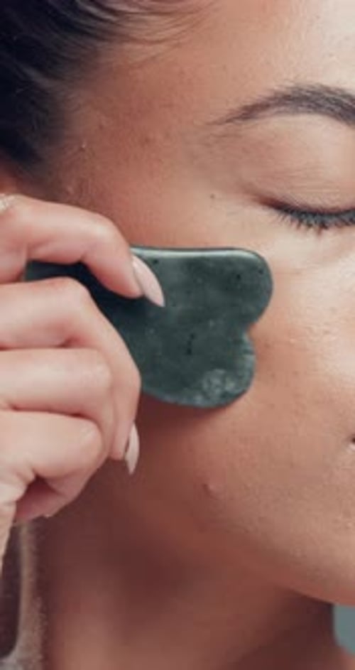 Beauty, gua sha and skincare with woman in studio for cosmetics, dermatology or wellness routine