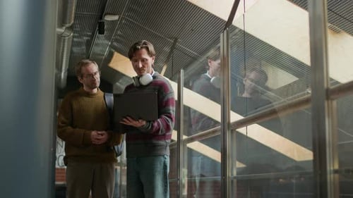 Male Developer Showing New Software on Laptop to His Colleague