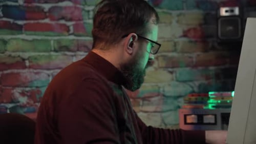 Mann fängt an, Audiokassetten vor einem Desktop-Computer aus den 1990er Jahren abzuspielen