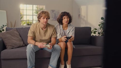 Friends Play Video Games on Living Room Couch