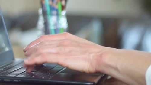 woman in office typing and paying a bill typing on her laptop with people stock video stock footage