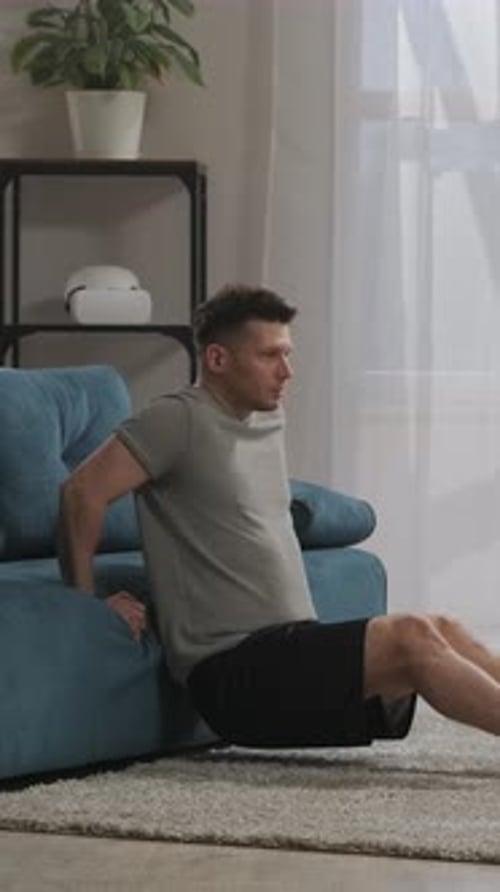 Man Doing Tricep Dips on Sofa in Living Room