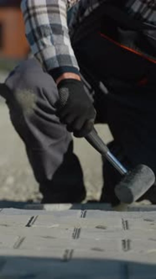 Construction Worker Laying Pavement Bricks
