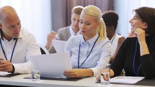 Business people discuss paperwork at a table