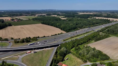 Traffic on multi-Land highway in American suburb. Rural landscape during sunny days with blue sky.