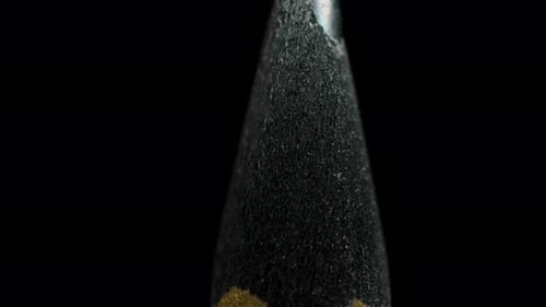 Black wooden pencil rotating on a black background. Slider. Macro. Sharp graphite tip.