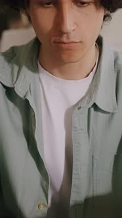 Man with Curly Hair Types on a Laptop