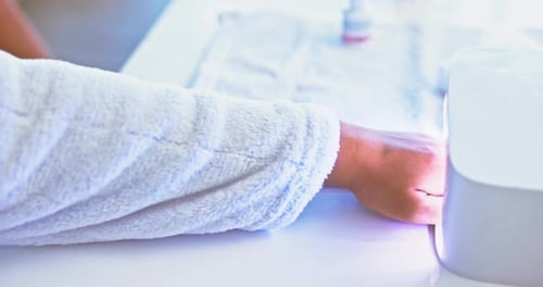 Hands on woman at salon, nail polish and LED lamp with technician for beauty
