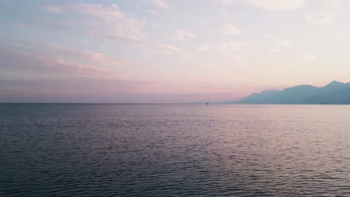 The Camera Quickly Flies Into the Sea Behind a Yacht Sailing in the Distance