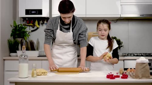 Slow Motion Boy in White Apron Rolls Dough with Rolling Pin on Table Girl Forms Cake in Hands Lovely