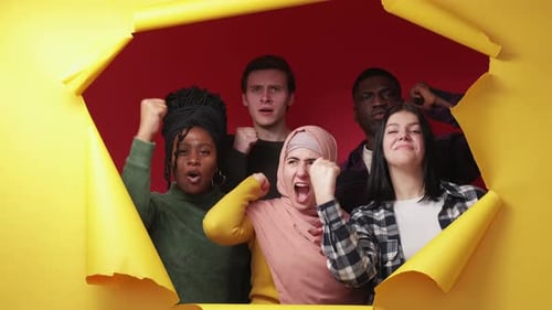 Group Raising Fists Through Paper Rip