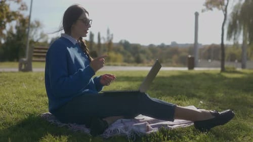 Student Girl Discussing on Laptop in a Park Setting Fall Season