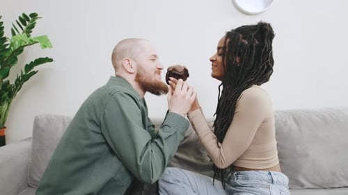 Young Couple Sharing a Cupcake and Kissing