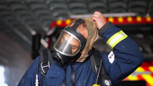 Firefighter Removing Gas Mask in Front of Firetruck