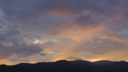 Dramatic Clouds at Sunset over Mountain Silhouette