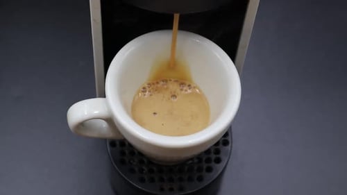 Coffee Being Brewed into a White Coffee Cup