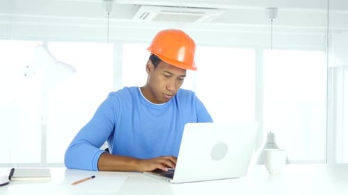 AfroAmerican Engineer Writing in Office Documentation