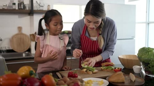 Girl and Woman Making Sandwiches Together in Kitchen