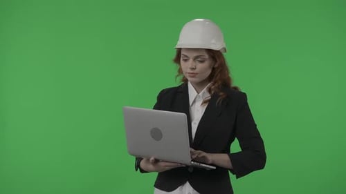 A Woman Architect Works on a Laptop Studies Plans Prints Reports Business Woman in a Protective