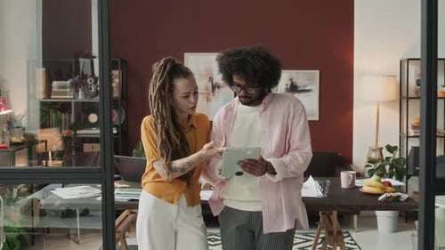 Colleagues Collaborating on Tablet in Bright Office