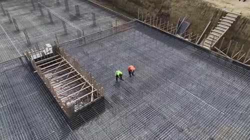 Luftaufnahme: Das Bauteam biegt den Bewehrungsstab und bereitet das Fundament vor